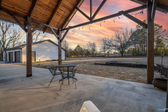 patio terrace at dusk with an outbuilding and a garage