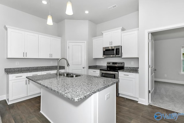 kitchen with white cabinets, a center island with sink, sink, appliances with stainless steel finishes, and decorative light fixtures