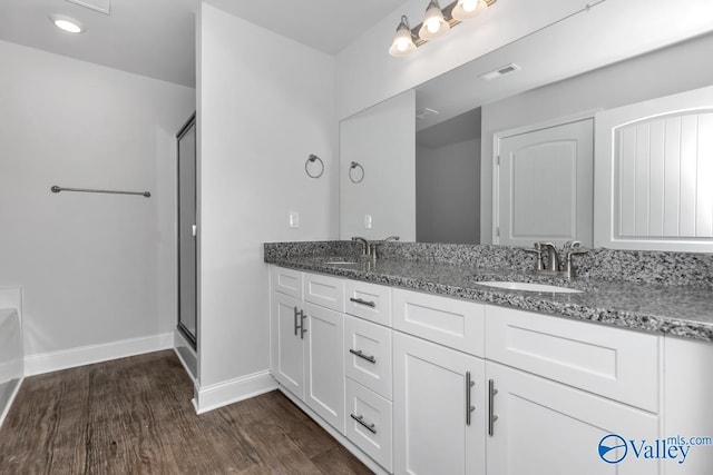 bathroom featuring vanity, an enclosed shower, and wood-type flooring