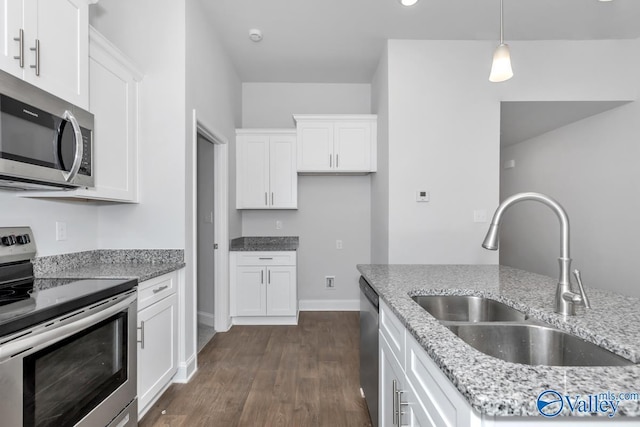 kitchen with white cabinets, stainless steel appliances, light stone counters, and sink