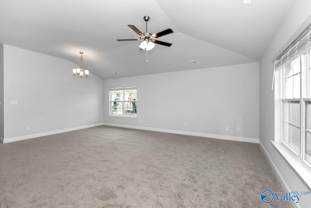 empty room featuring ceiling fan with notable chandelier, lofted ceiling, and carpet floors