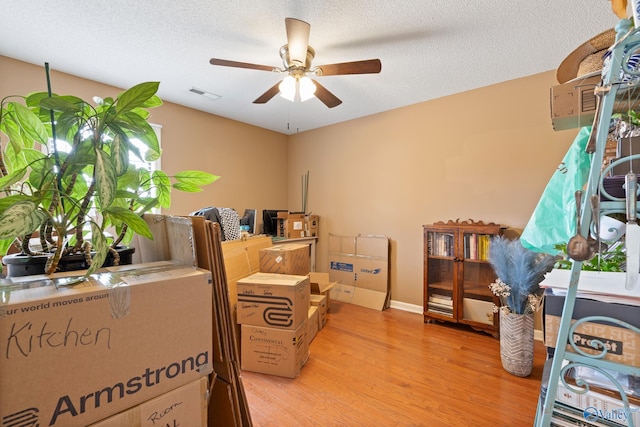 interior space featuring visible vents, light wood-style floors, ceiling fan, and a textured ceiling