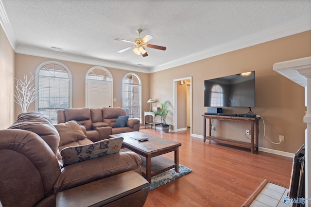 living area featuring light wood-type flooring, a wealth of natural light, a textured ceiling, and ceiling fan