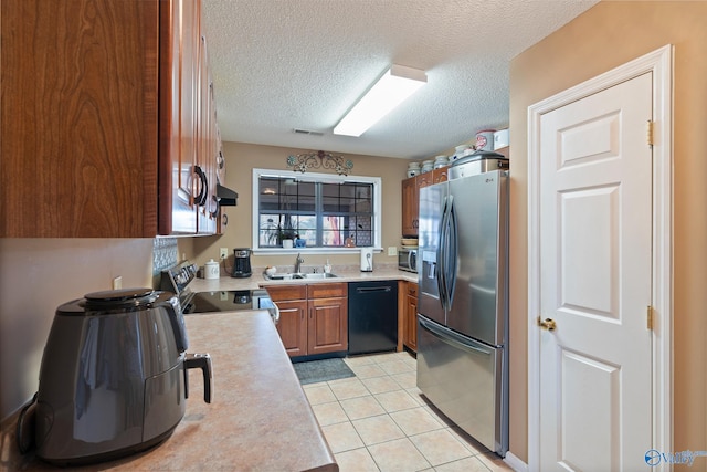 kitchen with light tile patterned flooring, light countertops, a sink, appliances with stainless steel finishes, and visible vents
