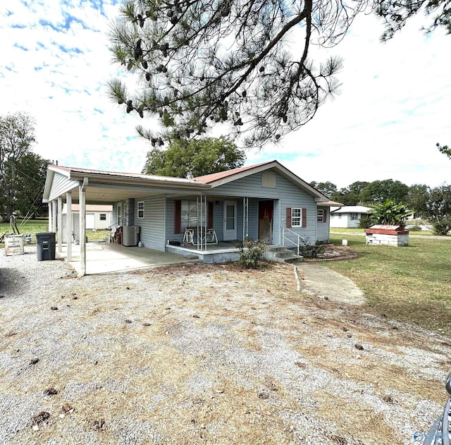 view of front of house with covered porch, driveway, and a carport