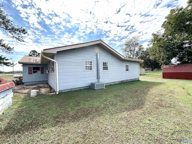 view of home's exterior with cooling unit and a lawn