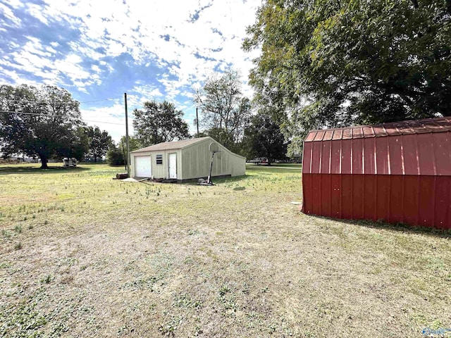 view of yard featuring a detached garage and an outbuilding