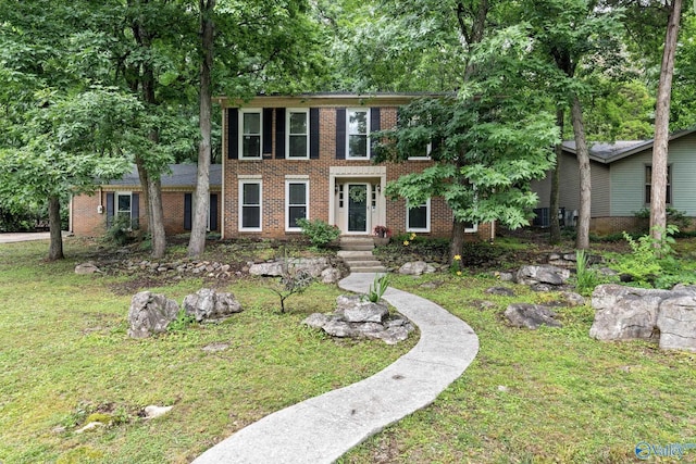 colonial-style house with brick siding and a front lawn