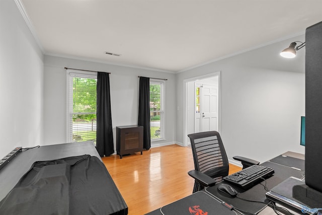 office space featuring ornamental molding, light wood finished floors, visible vents, and baseboards