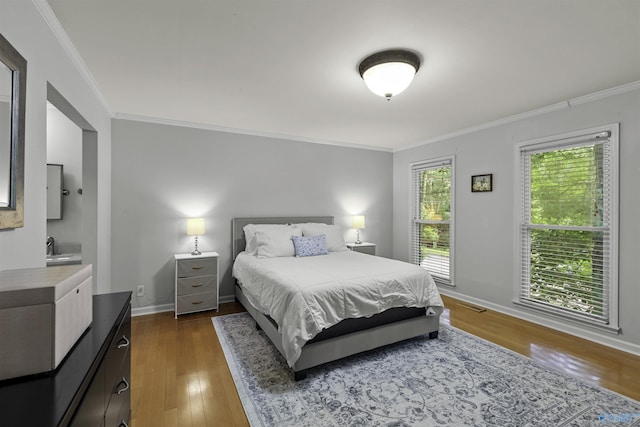 bedroom featuring crown molding, wood finished floors, and baseboards