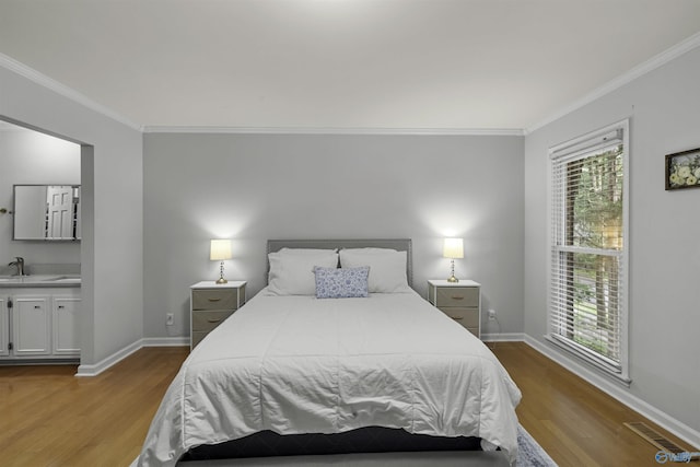 bedroom featuring ornamental molding, visible vents, baseboards, and wood finished floors