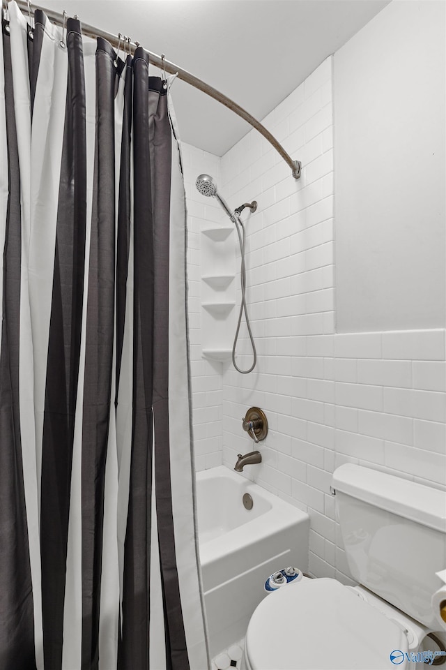 bathroom featuring shower / tub combo, toilet, and tile walls