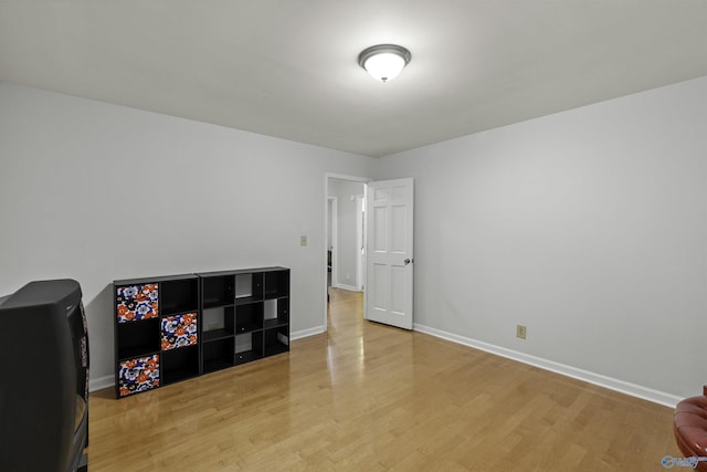 interior space featuring baseboards and light wood finished floors