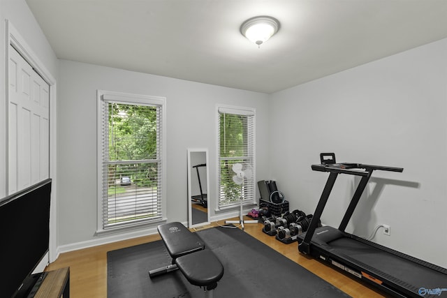 workout area with baseboards and wood finished floors