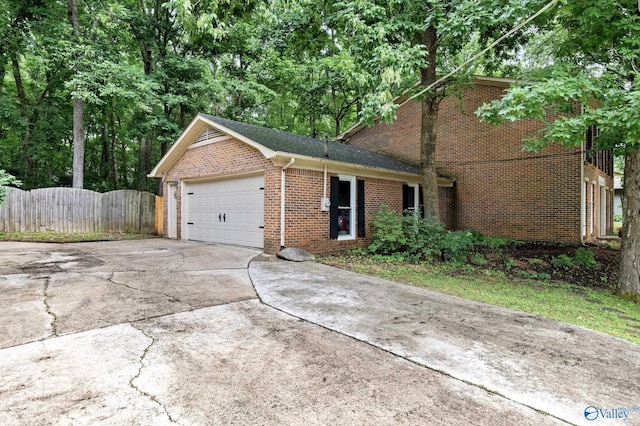 single story home with brick siding, fence, driveway, and an attached garage