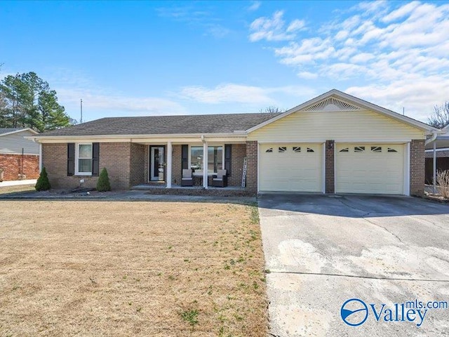 ranch-style home with a front lawn, brick siding, concrete driveway, and an attached garage