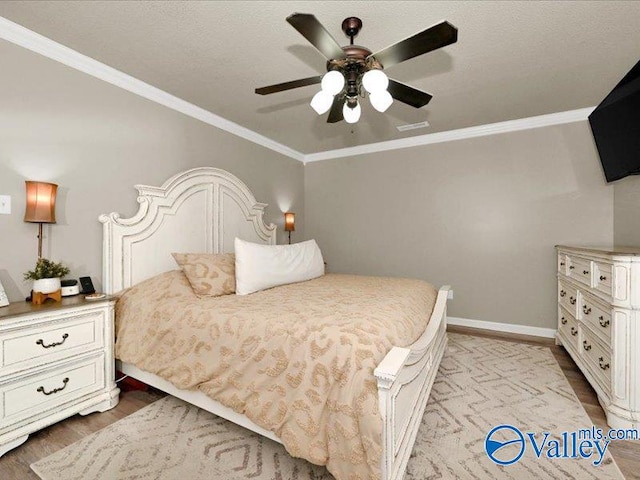 bedroom featuring ceiling fan, baseboards, wood finished floors, and ornamental molding