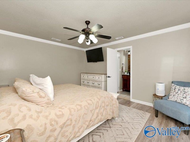 bedroom with visible vents, a textured ceiling, light wood-type flooring, and ornamental molding