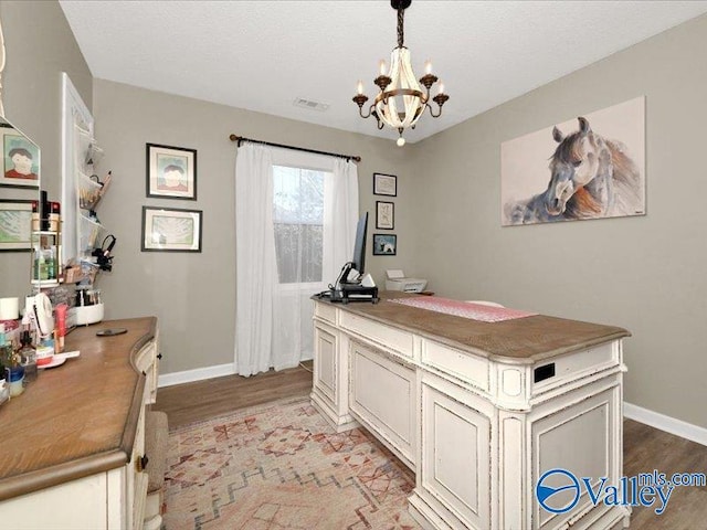 home office with light wood finished floors, a notable chandelier, baseboards, and visible vents