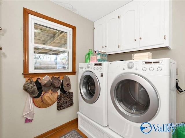 laundry room featuring washer and dryer, baseboards, and cabinet space