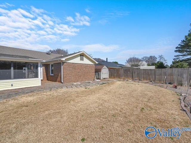 view of yard featuring an outbuilding, a storage shed, and fence