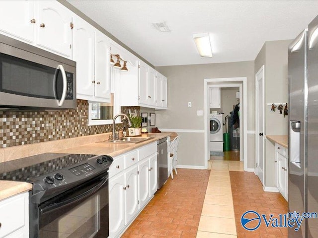 kitchen featuring decorative backsplash, washer / dryer, white cabinets, stainless steel appliances, and a sink