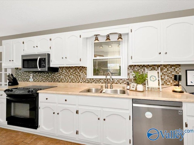 kitchen featuring a sink, appliances with stainless steel finishes, and white cabinetry