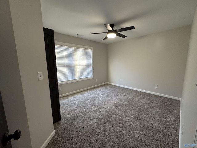 unfurnished room featuring baseboards, a ceiling fan, and dark colored carpet