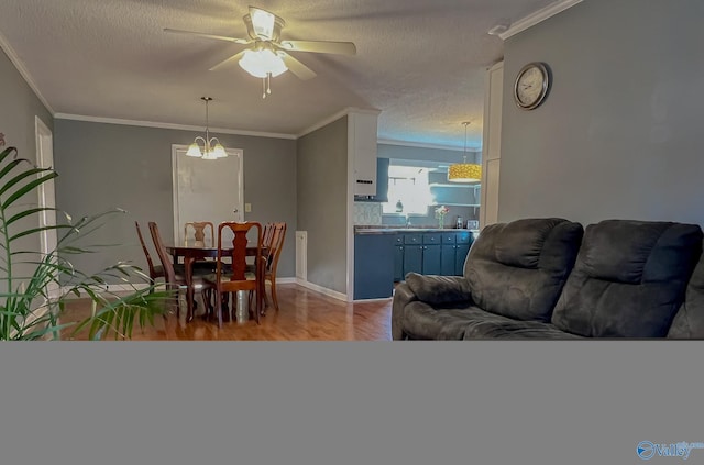 dining space with baseboards, wood finished floors, crown molding, a textured ceiling, and ceiling fan with notable chandelier