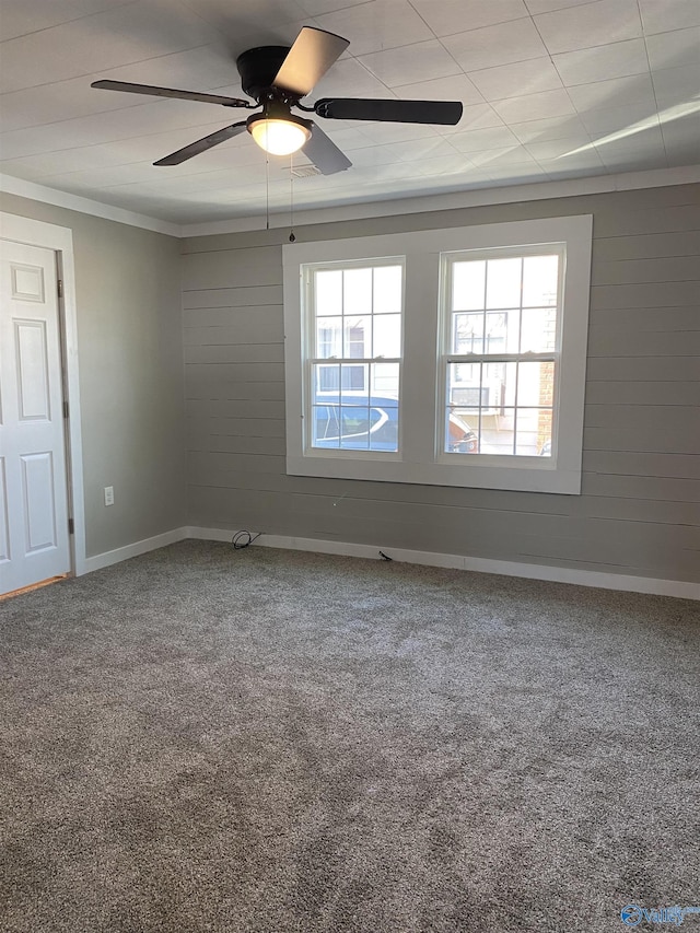 carpeted spare room with ceiling fan and ornamental molding