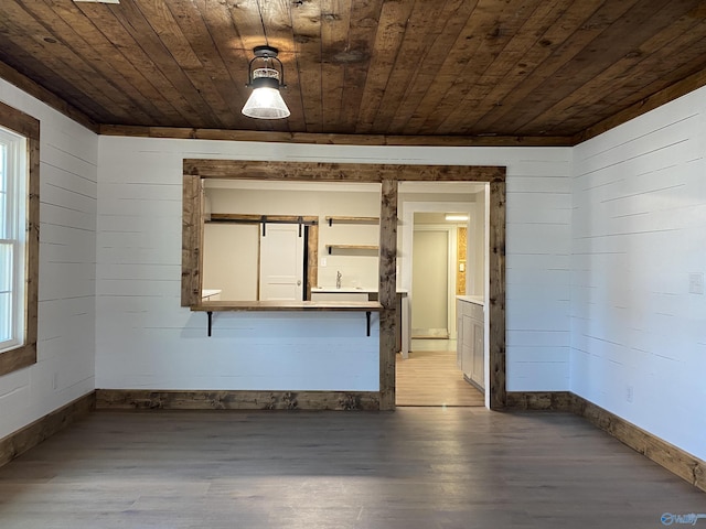 unfurnished room with hardwood / wood-style floors, wood ceiling, and wooden walls