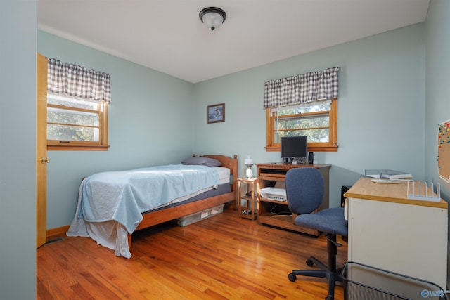 bedroom with hardwood / wood-style flooring and multiple windows