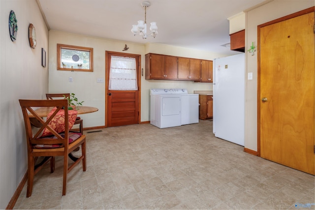 washroom with cabinets, washer and dryer, and a chandelier