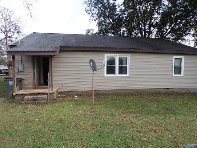 rear view of property featuring a yard