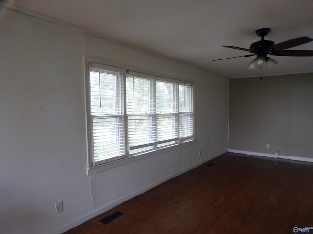 spare room featuring ceiling fan, plenty of natural light, and dark hardwood / wood-style flooring