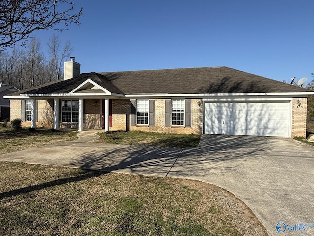 ranch-style home featuring a chimney, concrete driveway, a garage, and brick siding