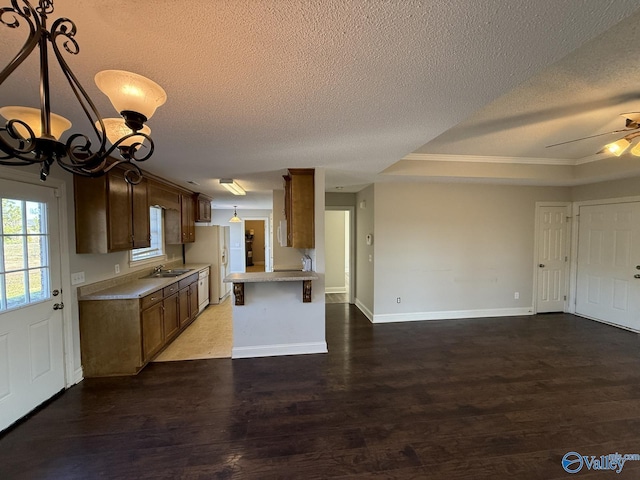 kitchen featuring light countertops, wood finished floors, open floor plan, and baseboards