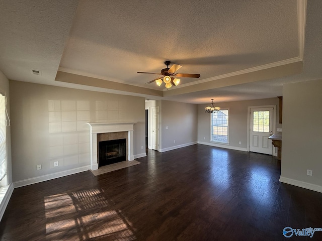 unfurnished living room featuring baseboards, visible vents, dark wood finished floors, a tile fireplace, and ceiling fan with notable chandelier