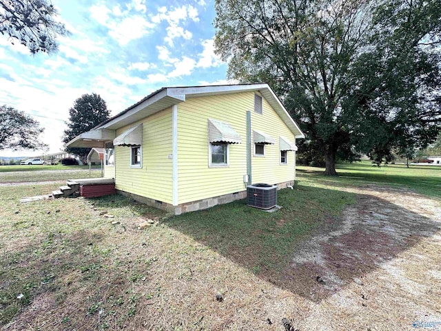 view of side of property with central air condition unit, a lawn, and crawl space