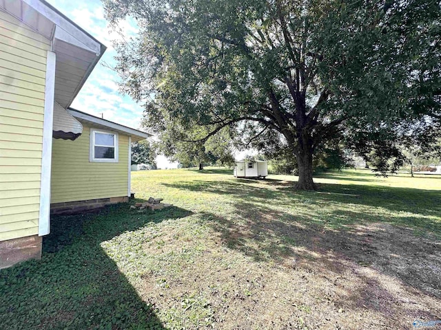 view of yard featuring a storage unit and an outbuilding