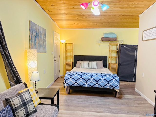 bedroom with fridge, wood finished floors, wooden ceiling, and baseboards