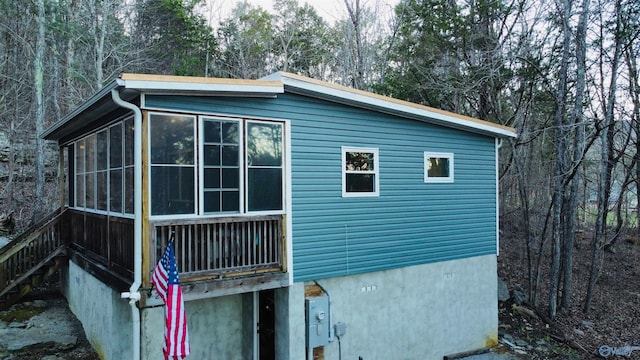 view of property exterior with a sunroom