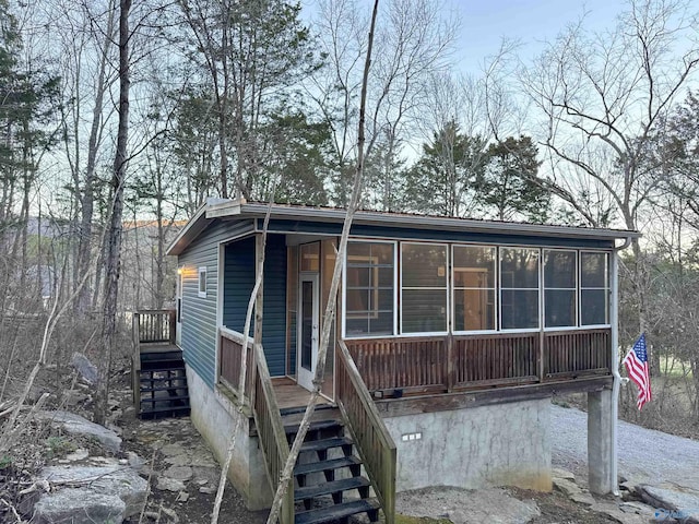 view of front of house with stairway and a sunroom