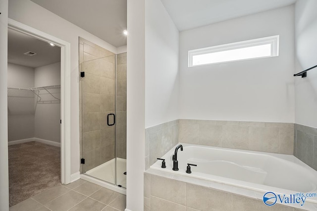 bathroom with tile patterned floors and shower with separate bathtub