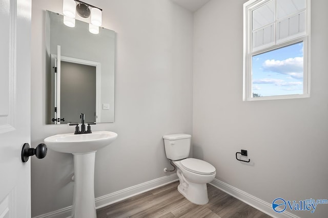 bathroom with sink, toilet, and hardwood / wood-style flooring