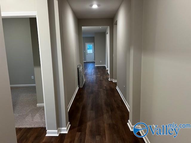 corridor with dark hardwood / wood-style flooring