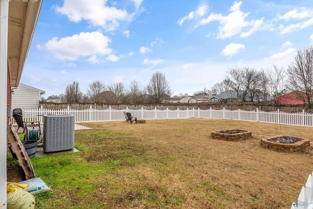 view of yard with cooling unit and an outdoor fire pit