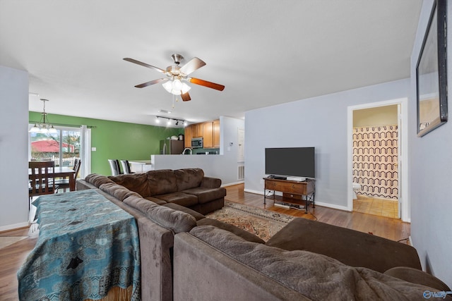 living room featuring ceiling fan and light wood-type flooring