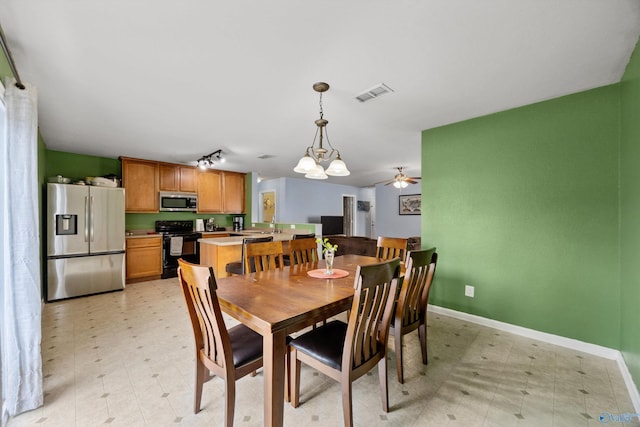 dining area with ceiling fan with notable chandelier and track lighting