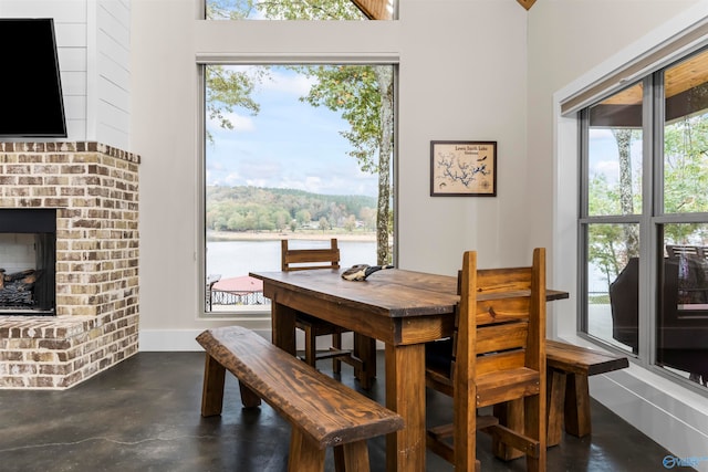 dining space featuring a water view and a fireplace